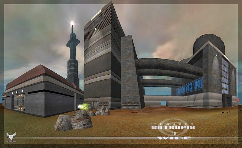 A modern building complex in a barren landscape with a tall skyscraper and an industrial structure.